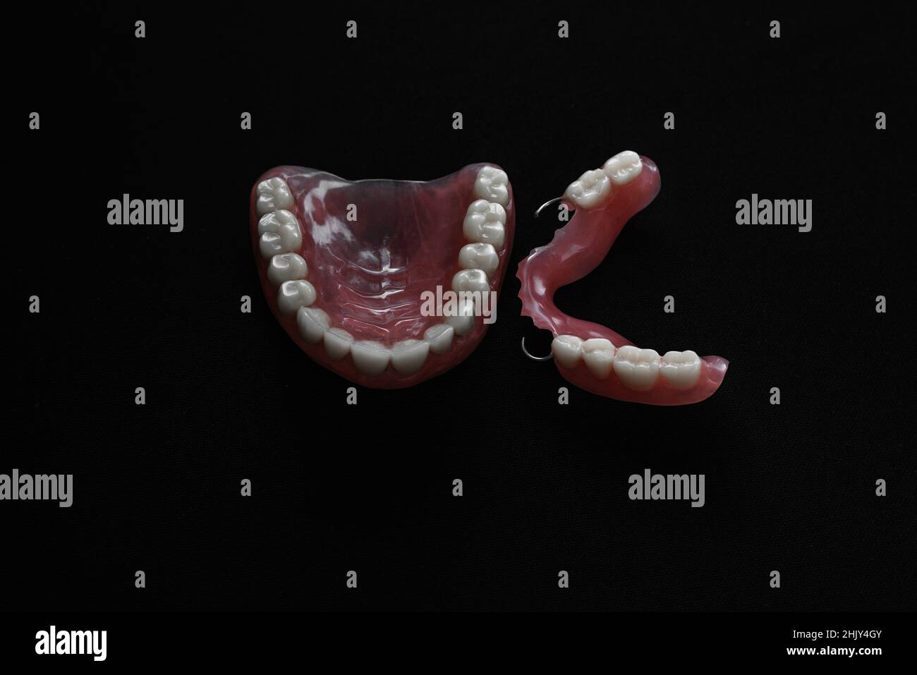 Dentiera completamente rimovibile in plastica delle ganasce. Una serie di dentini su sfondo nero. Due protesi acriliche. Ganasce superiore e inferiore con denti falsi. Dentu Foto Stock