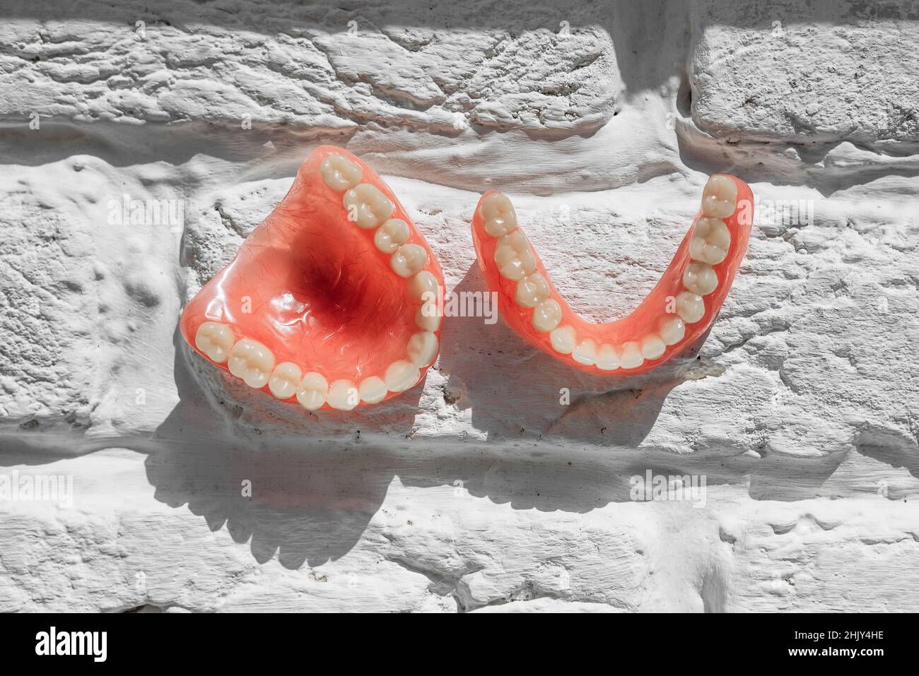 Dentiera completamente rimovibile in plastica delle ganasce. Una serie di dentini su sfondo chiaro. Due protesi acriliche. Ganasce superiore e inferiore con denti falsi. Dentu Foto Stock