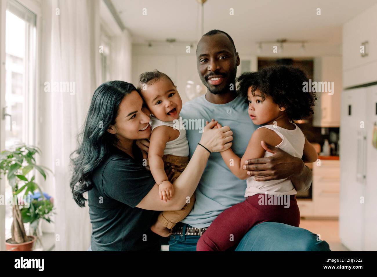 Genitori felici con bambini in cucina a casa Foto Stock