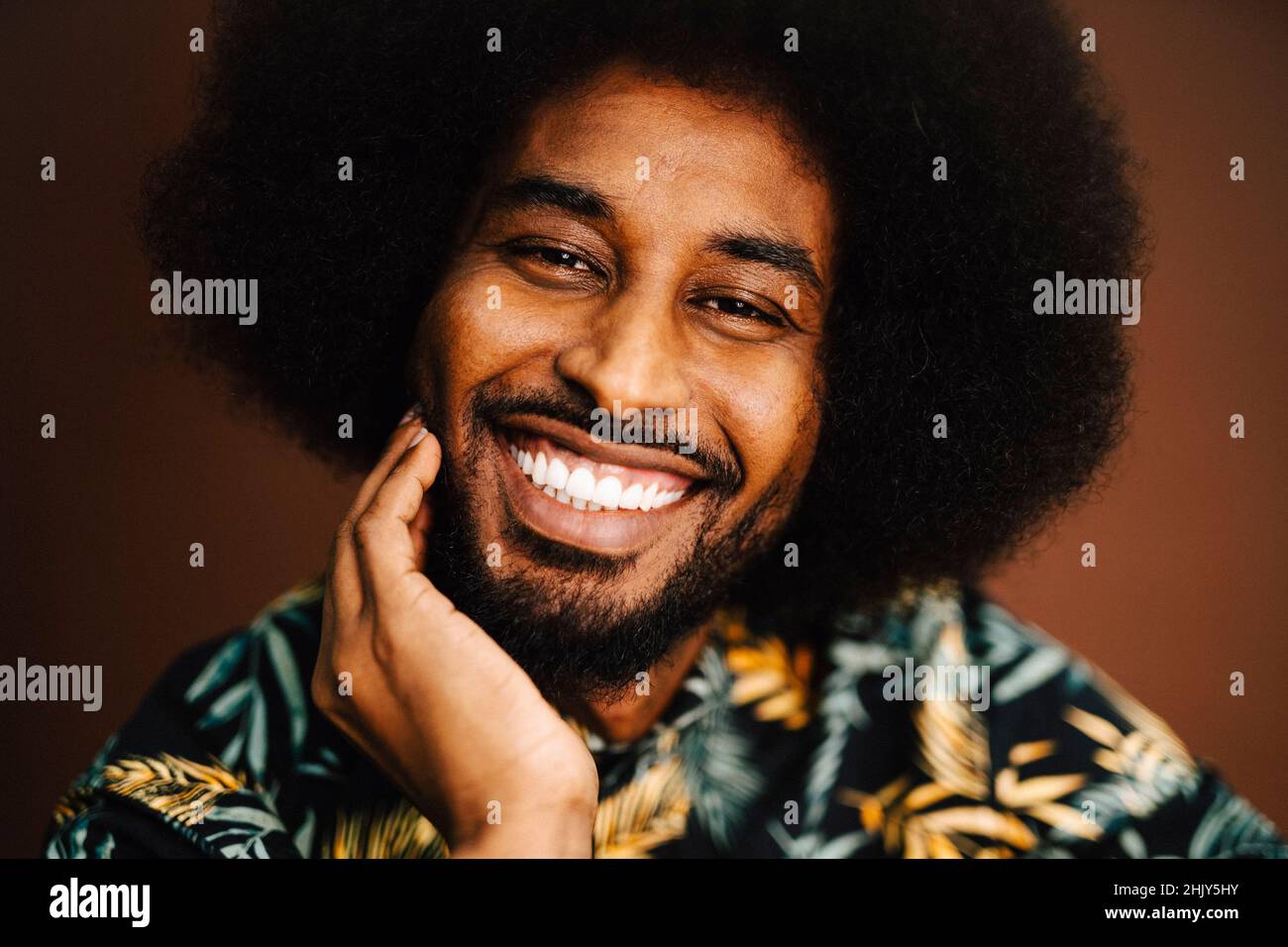 Ritratto di uomo felice con mano sul mento in studio Foto Stock