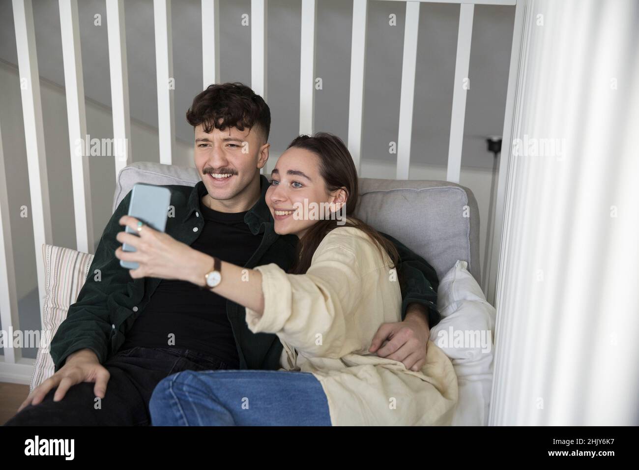 Felice giovane coppia che prende selfie su smartphone in camera da letto Foto Stock