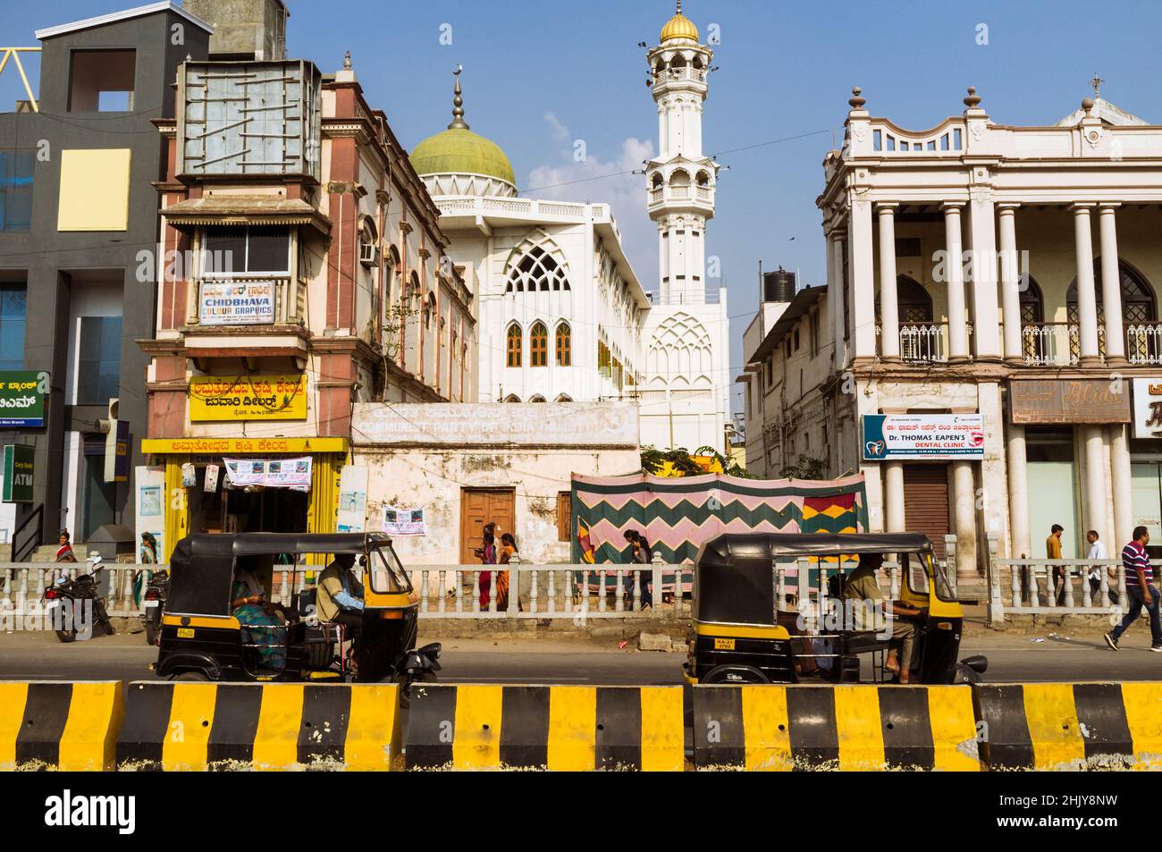 Mysore, Karnataka, India : Auto-rickshaws guidare oltre una moschea a Ashoka rd. Nel centro di Mysore. Foto Stock