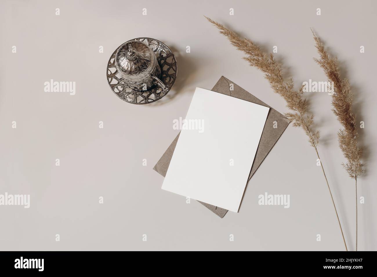 Tazza decorativa in argento turco con tè. Erba secca. Su tavolo beige. Biglietto d'auguri mockup per la comunità musulmana santo mese Ramadan Kareem o boho matrimonio Foto Stock