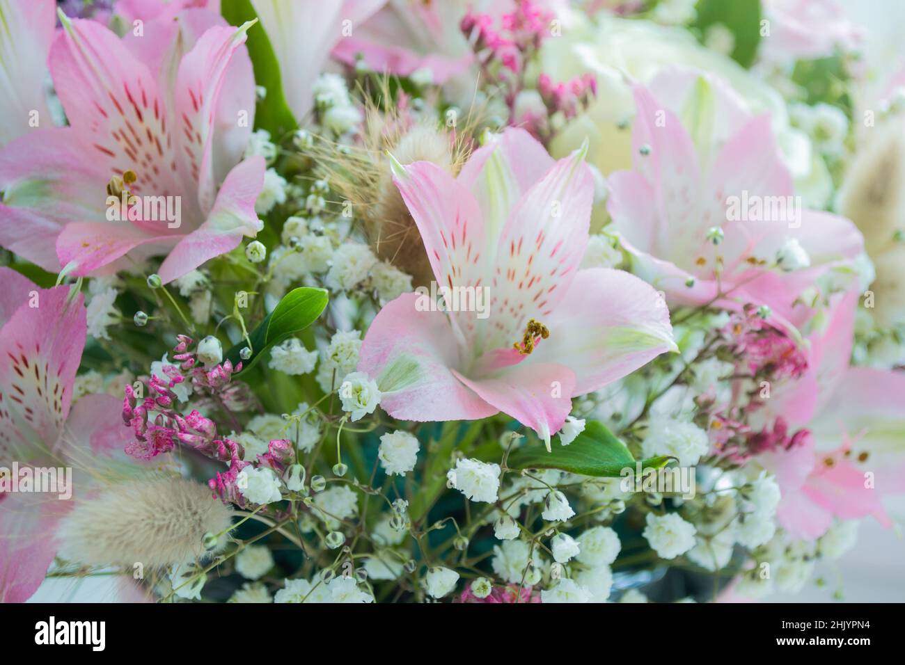Primo piano di delicati fiori di gigli rosa, rose bianche, gypsofila. Sfondo floreale. Spazio di copia. Foto Stock