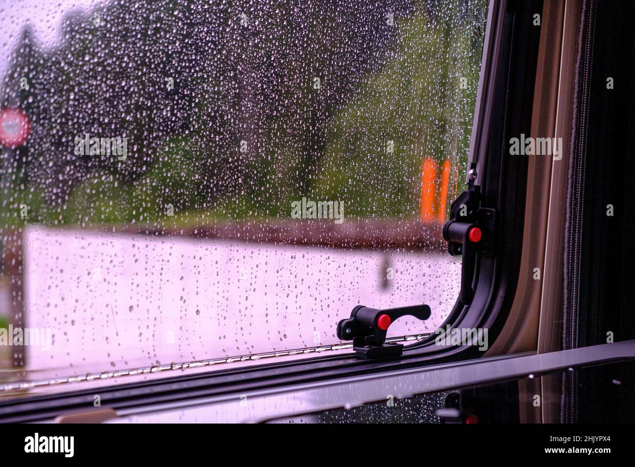 Guardando attraverso una finestra di un camper durante una giornata di pioggia nelle alpi Foto Stock