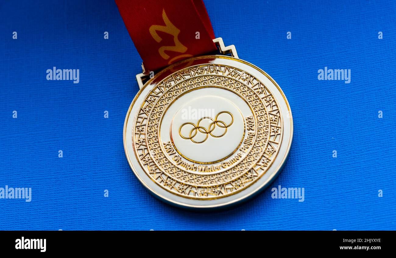 27 gennaio 2022, Pechino, Cina. XXIV medaglia d'oro dei Giochi Olimpici invernali su sfondo blu. Foto Stock