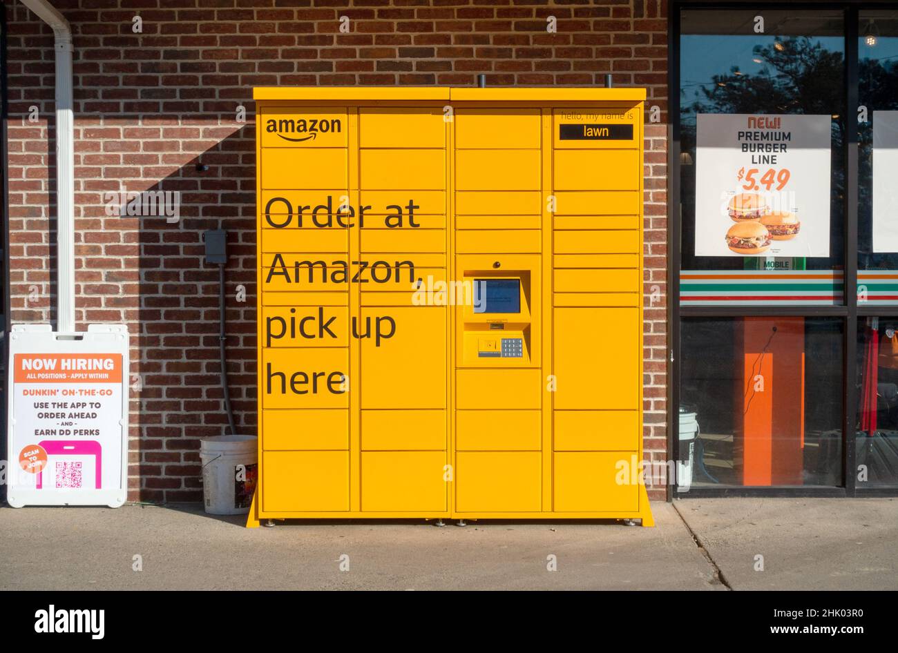 Amazon Locker Kiosk per il ritiro di pacchi Ordine da rivenditori online all'aperto tra un negozio 7-11 & Dunkin Donuts Foto Stock