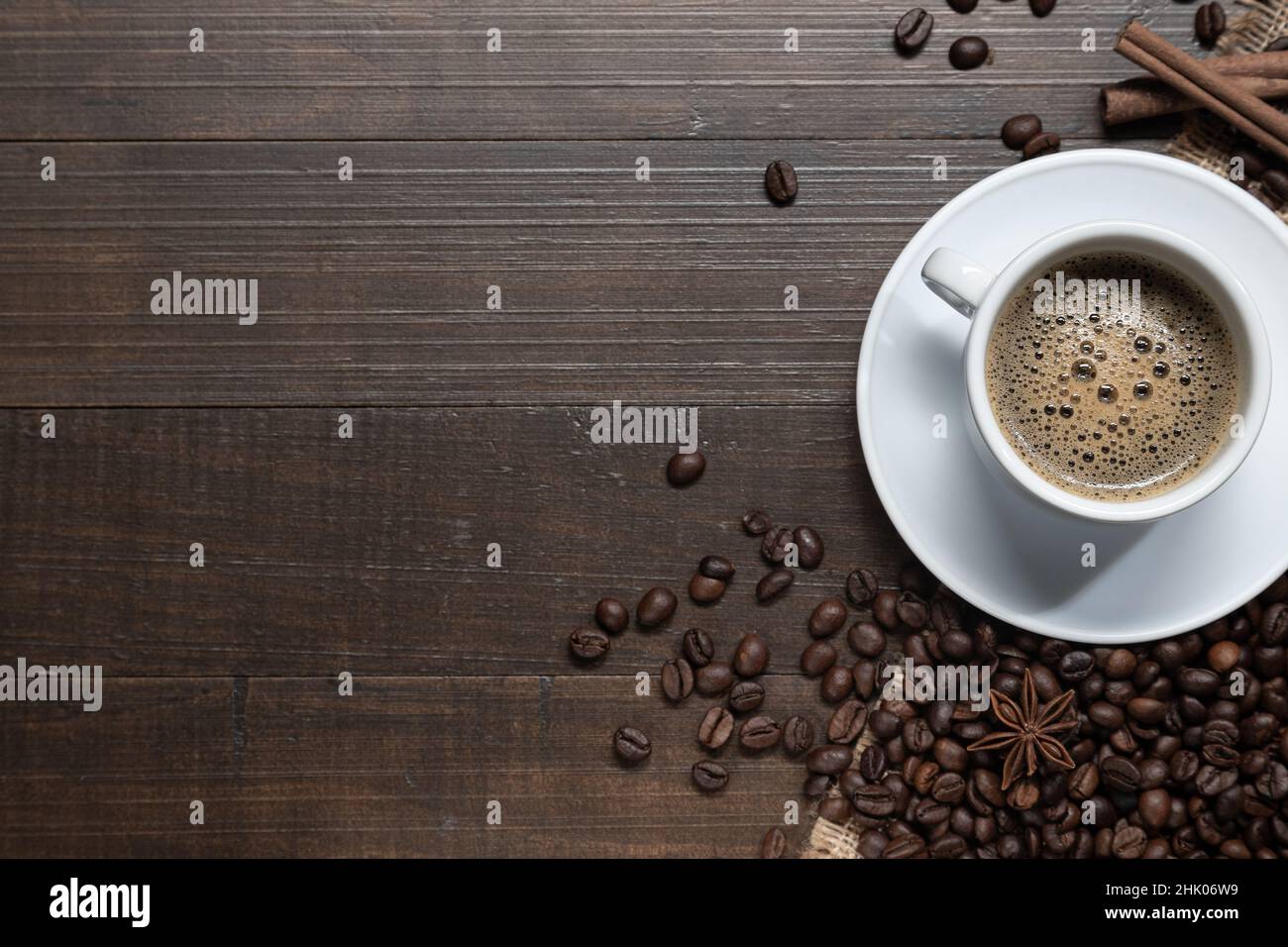 Vista dall'alto. Cappuccino caldo su vecchio tavolo di legno scuro. Bevi il concetto di caffè con copyspace. Composizione della disposizione piatta Foto Stock