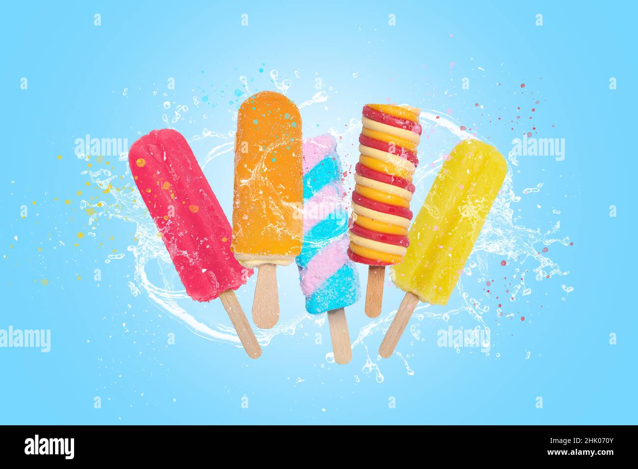 Gelato colorato Possicicles su sfondo blu con spruzzi. Foto Stock
