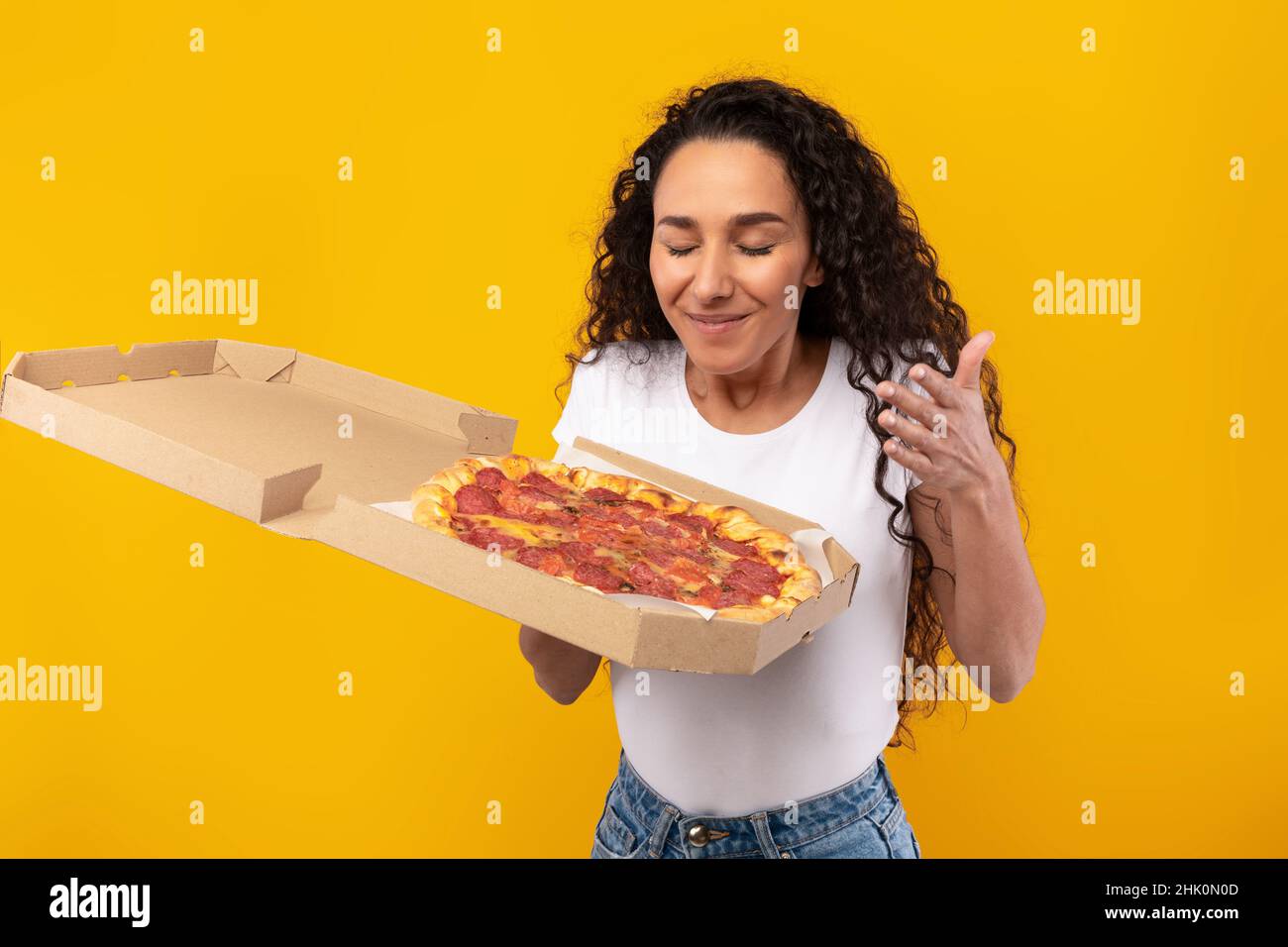 Ritratto di Happy Latin Lady Holding Pizza Foto Stock