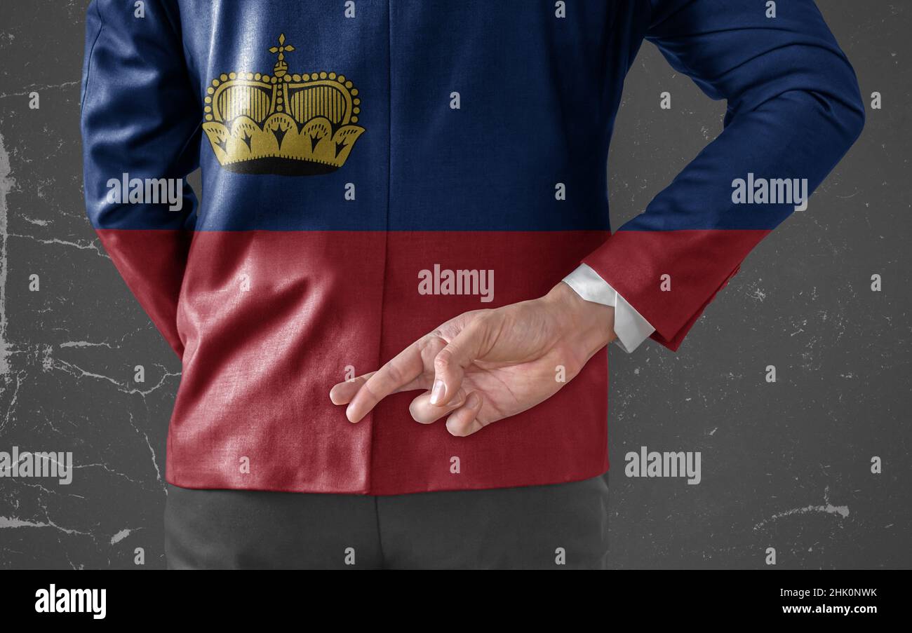 Giacca uomo d'affari con bandiera del Liechtenstein con le dita incrociate dietro la schiena Foto Stock