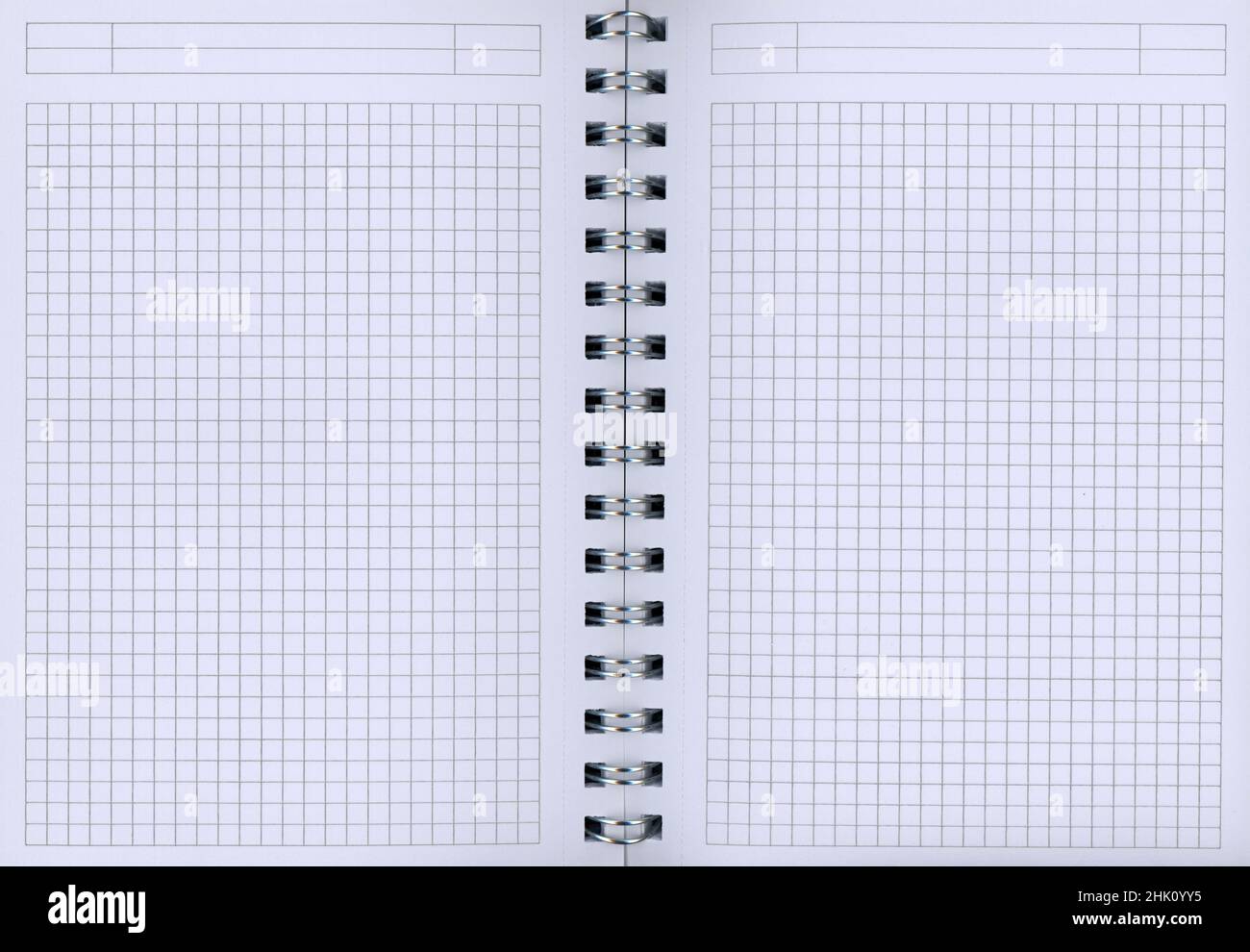 Un blocco a spirale aperto con carta a scacchi bianca Foto Stock