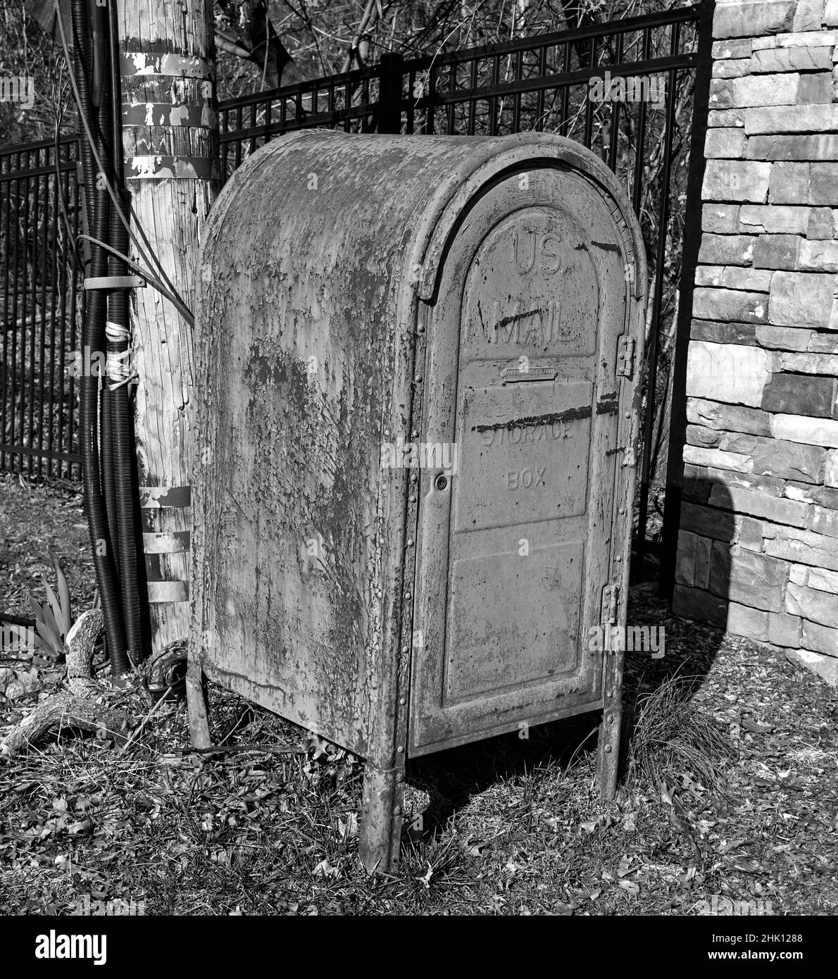 Un vecchio arrugginito,intemperiato,mailbox,in bianco e nero. Questo è anche chiamato dropbox per i vettori di posta a ritirare la posta da consegnare. Foto Stock