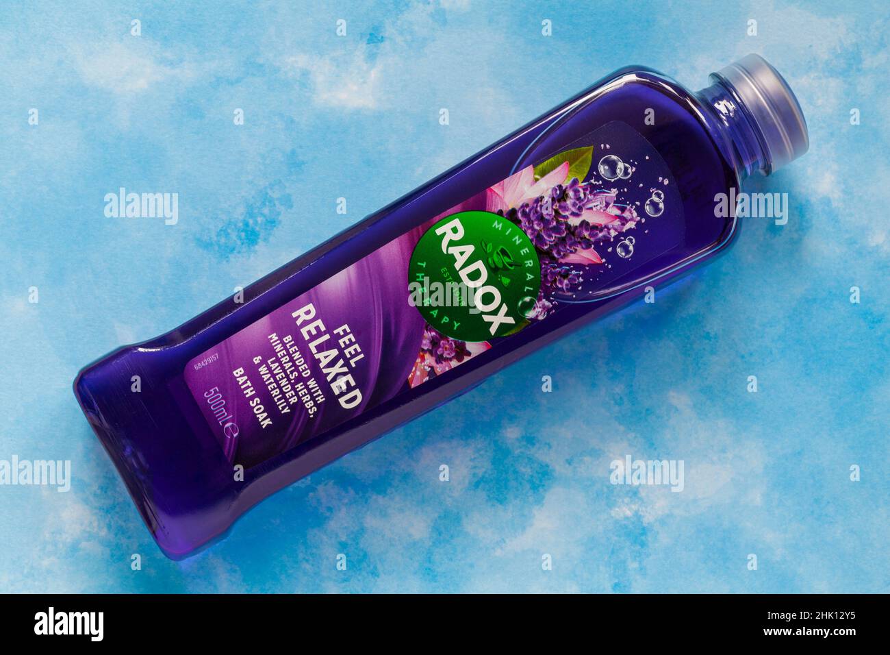 Bottiglia di Radox sentirsi rilassato mescolato con minerali, erbe, lavanda e bagno d'acqua immergere su sfondo blu motivi Foto Stock
