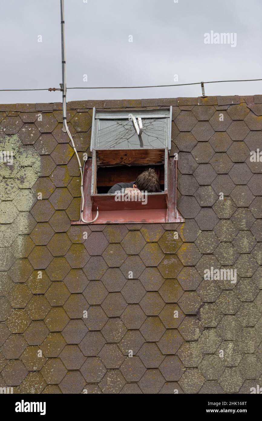 Un vetro lucernario aperto sul tetto con una persona non identificabile Foto Stock