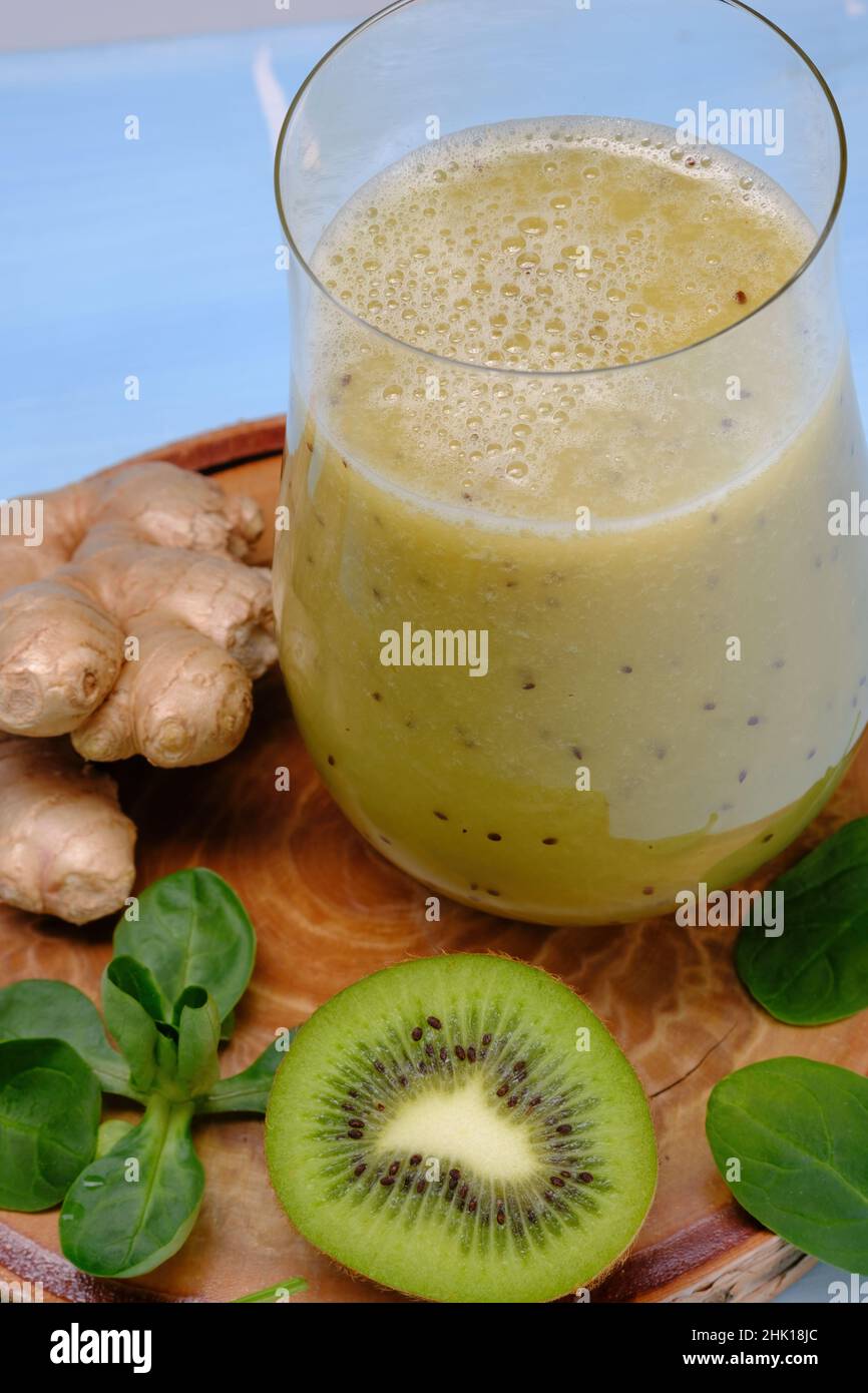 Bicchiere di spinaci verdi, arancia, zenzero e kiwi sani frullati. Foto Stock
