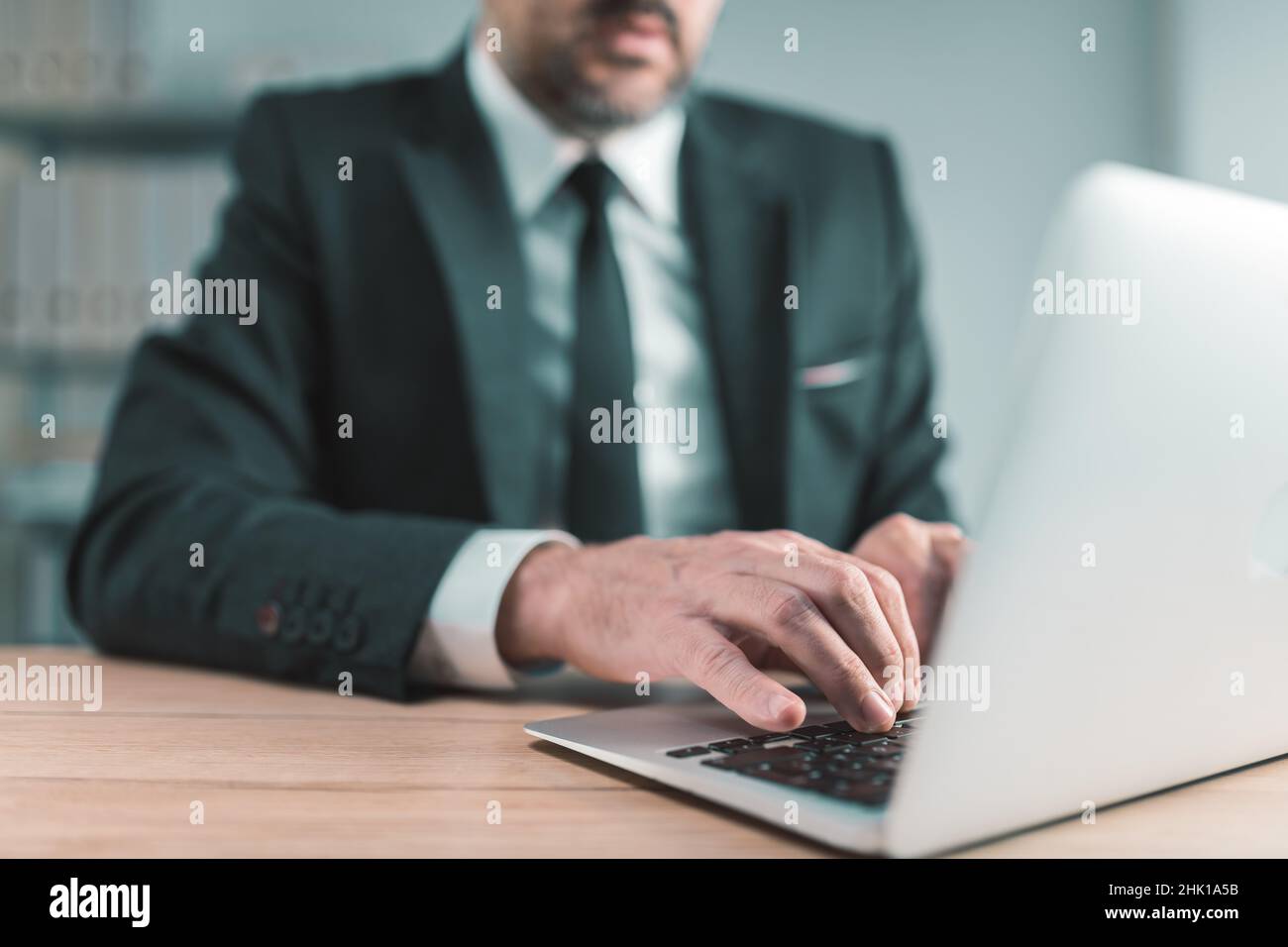 Persona d'affari che digita la tastiera del computer portatile nell'ufficio dell'azienda, primo piano con fuoco selettivo Foto Stock