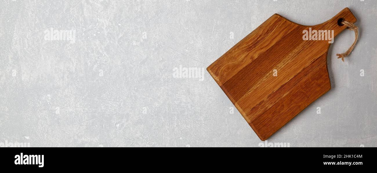 Tagliere di legno marrone su un tavolo di cemento grigio Foto Stock