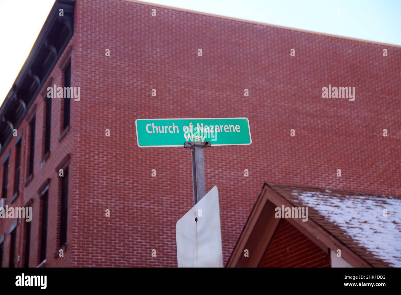 Green Church of Nazarene Way segno appeso su un palo grigio con mattoni rossi muro sul retro in Paulus Hook a Jersey City Foto Stock