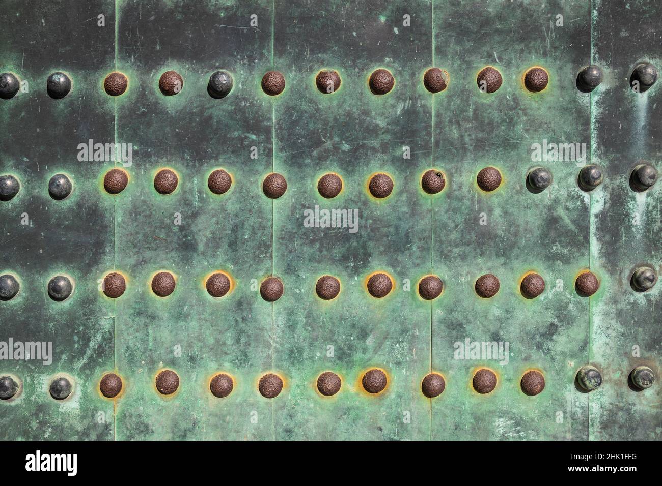 Un primo piano dei bulloni di uno sportello in rame spesso che è stato ossidato di verde con lo spazio di copia. Foto Stock