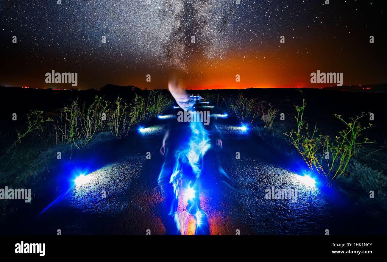 Entità aliena traslucida su una sola strada di campagna Foto Stock