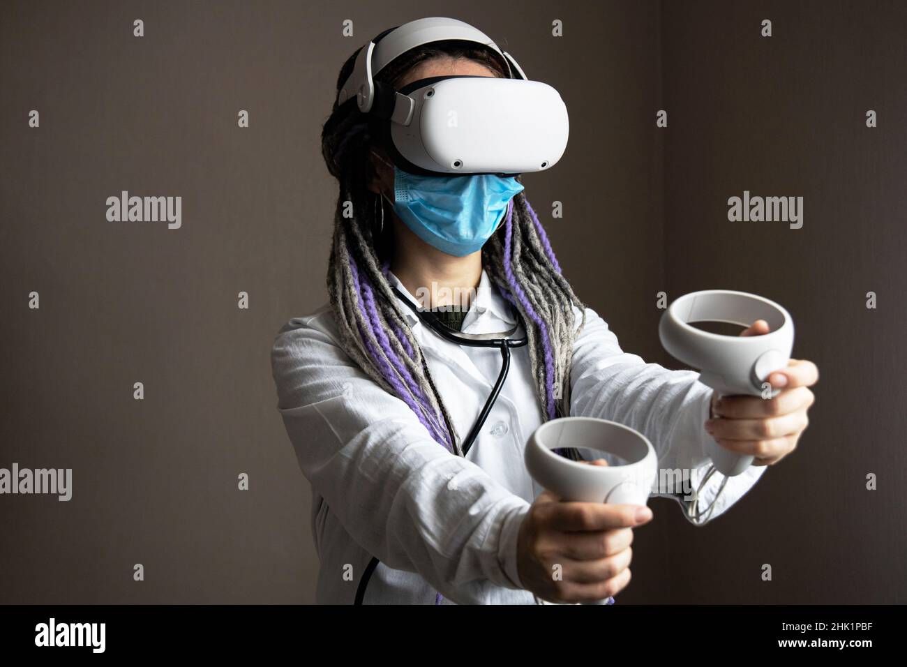 L'operatore medico nel casco di realtà virtuale sta tenendo i joystick Foto Stock