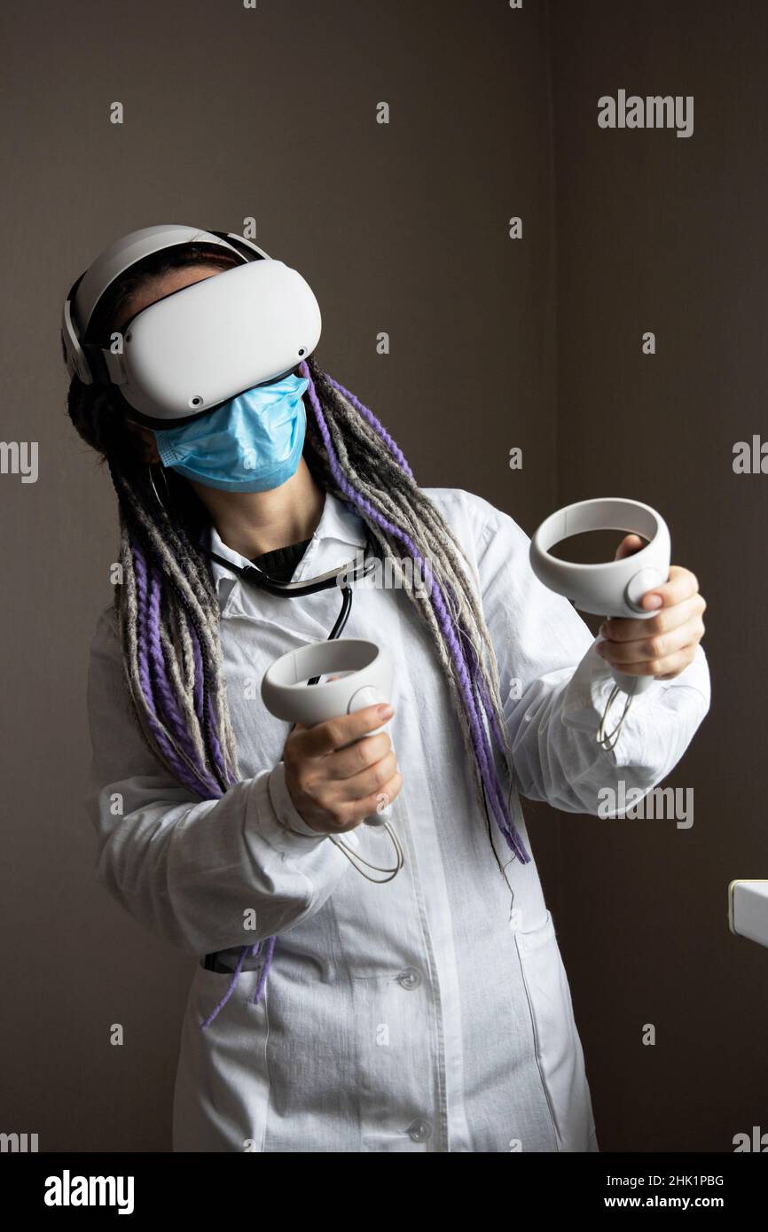 L'operatore medico nel casco di realtà virtuale sta tenendo i joystick Foto Stock