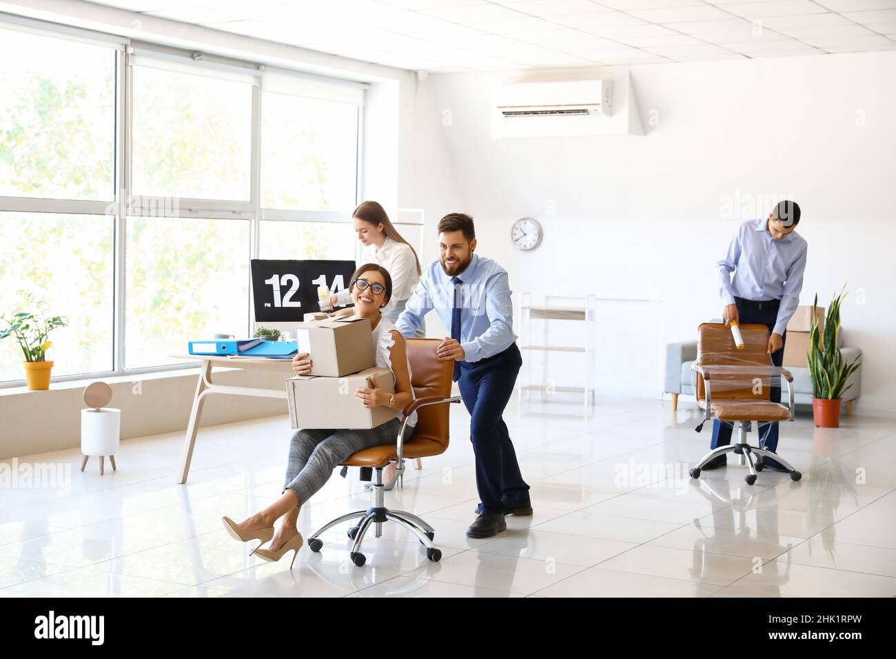 I colleghi di lavoro si divertono mentre si imballano le cose in ufficio il giorno in movimento Foto Stock
