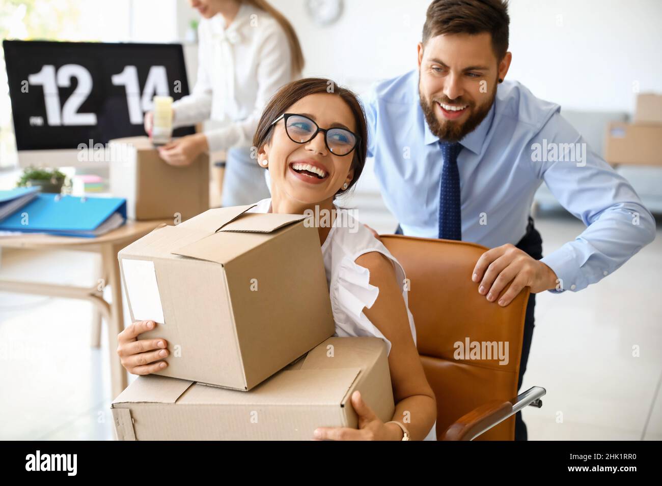 I colleghi di lavoro si divertono mentre si imballano le cose in ufficio il giorno in movimento Foto Stock