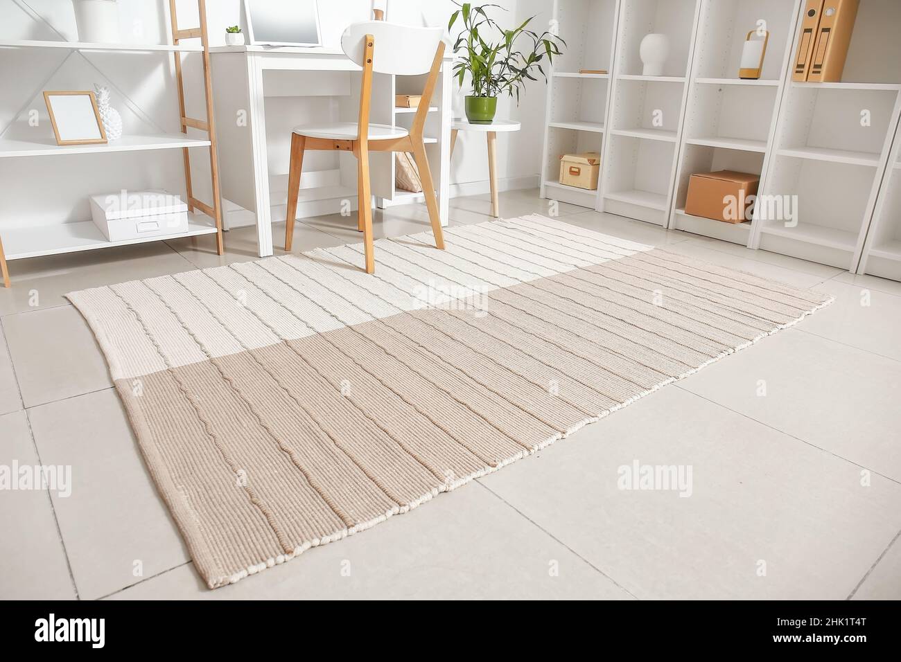 Moquette su pavimento piastrellato in camera luminosa Foto stock - Alamy