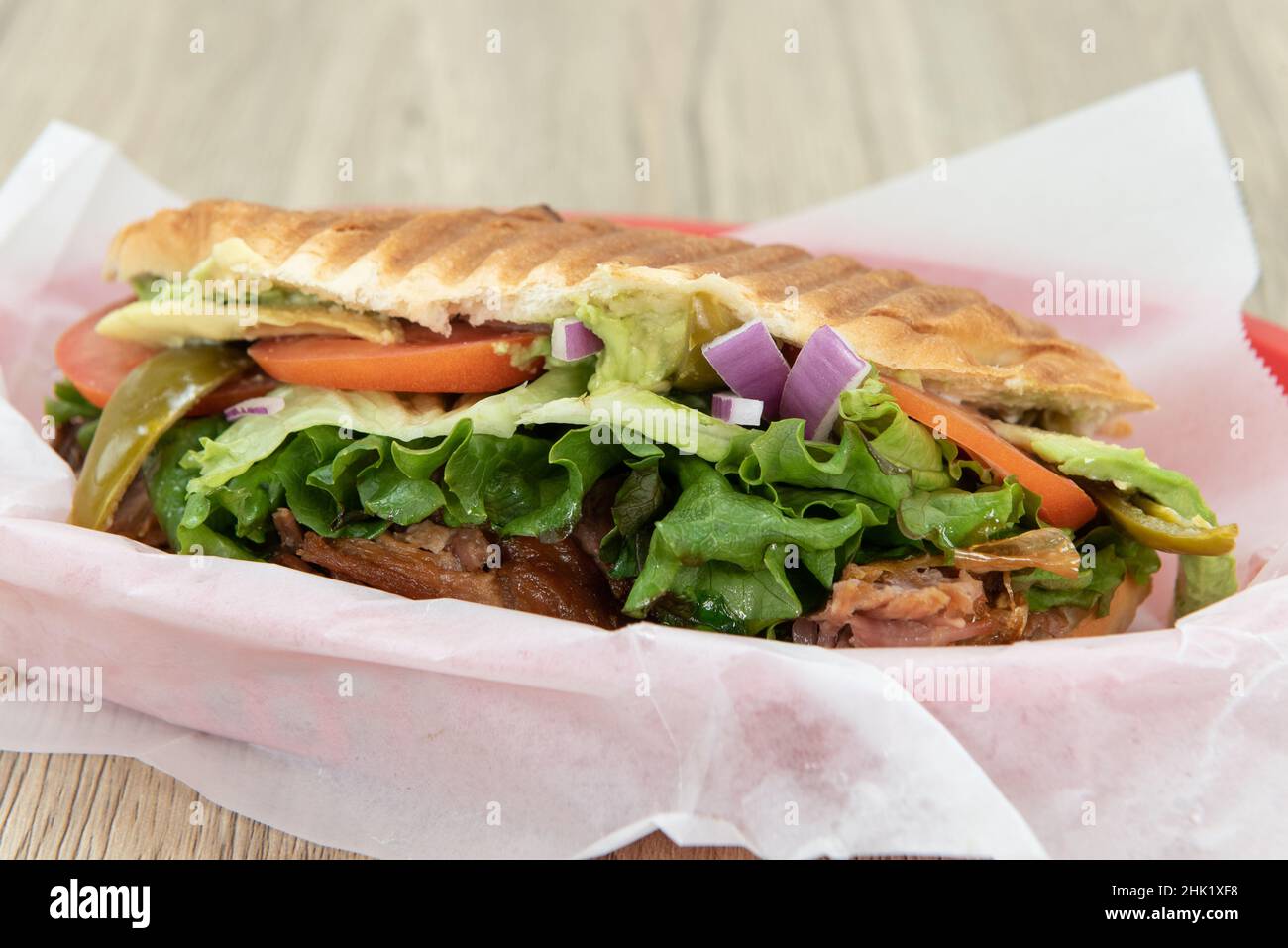 Enorme sandwich di carnitas torta è carico e traboccante di ingredienti tritati e deliziosa carne di maiale. Foto Stock