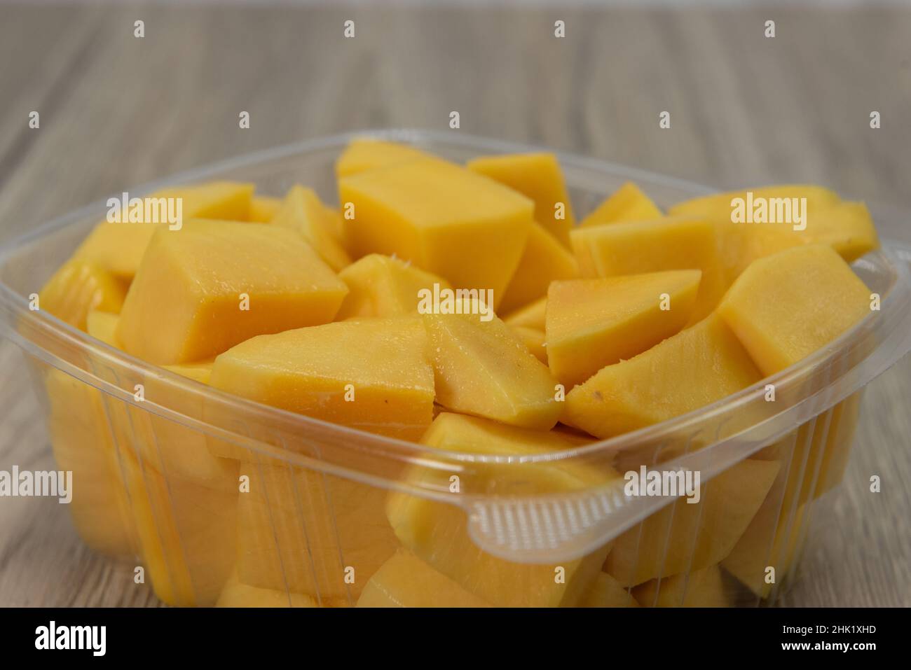 Grande ordine di estrazione di pezzi di frutta di cantalupo che riempiono la scatola di plastica. Foto Stock