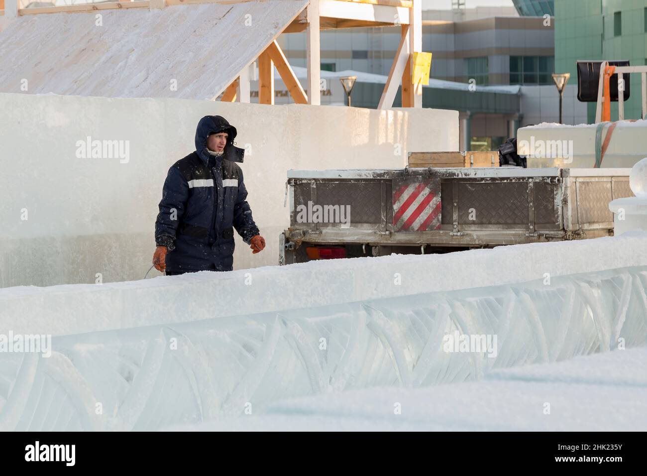 Lavoratore con un cucchiaio in mano in corrispondenza del sito di assemblaggio della città di ghiaccio Foto Stock
