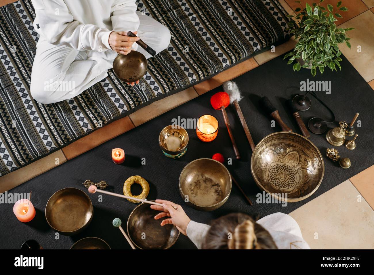 Vista dall'alto delle ciotole cantanti, terapia alternativa di guarigione del suono. Donna che suona con strumenti di musica a percussione. Cura della salute mentale con meditazione Foto Stock