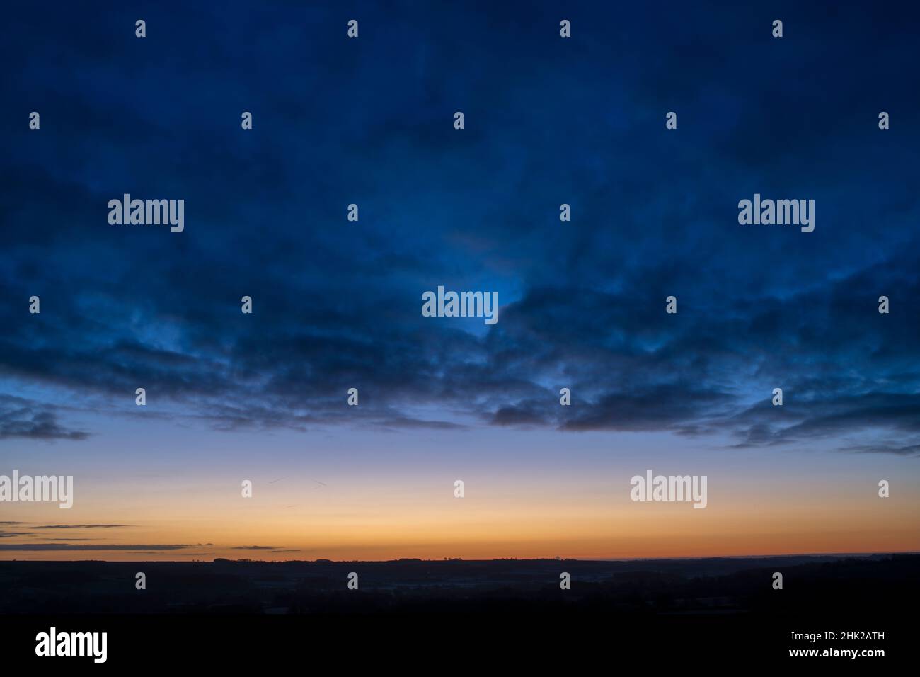 Cielo nuvoloso blu all'alba nella campagna del cotswold. Cotswolds, Gloucestershire, Inghilterra Foto Stock