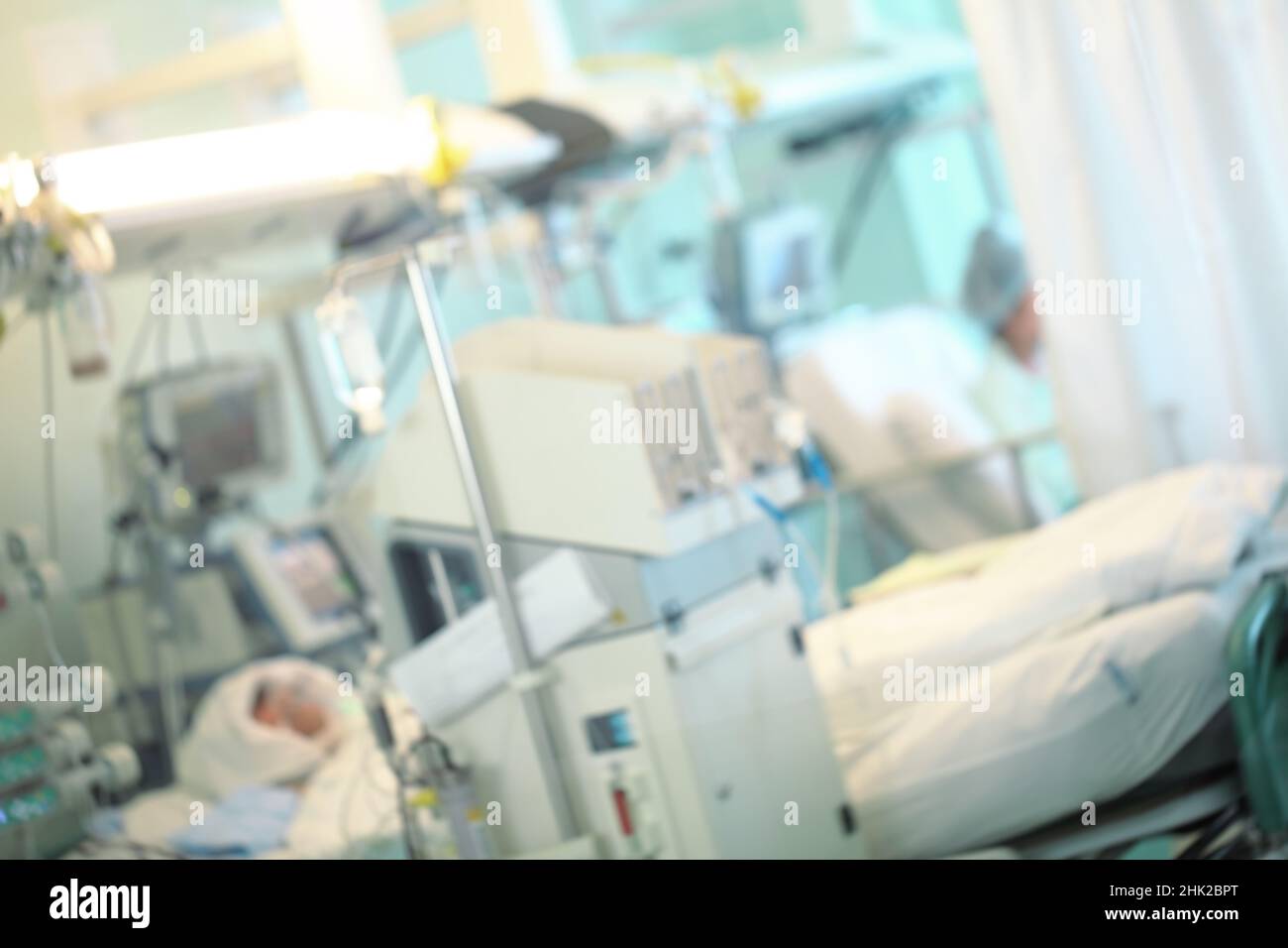 Paziente nell'unità di terapia intensiva circondato da apparecchiature di supporto alla vita avanzate, sfondo non focalizzato. Foto Stock Paziente nell'unità di terapia intensiva circondato da apparecchiature di supporto alla vita avanzate, sfondo non focalizzato. Foto Stock