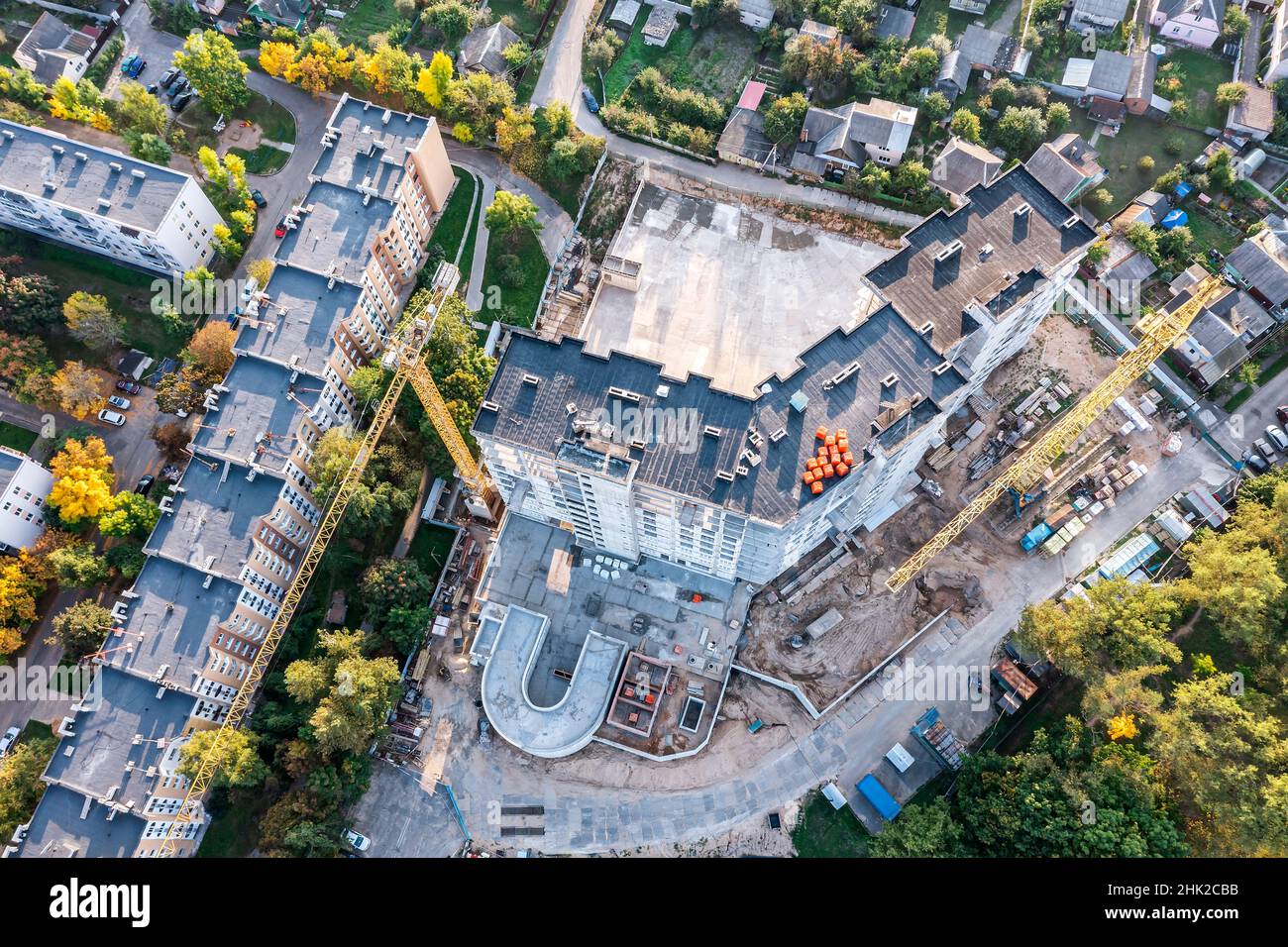 cantiere in quartiere residenziale. vista aerea di nuovo edificio con gru edili. Foto Stock