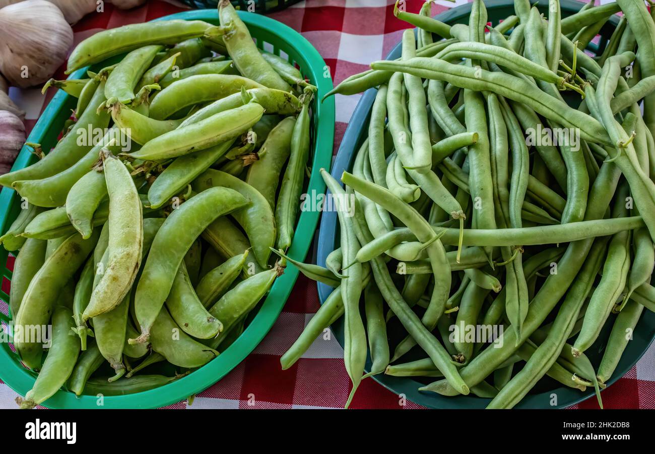 Piselli verdi e fagioli verdi in vendita al mercato agricolo in estate. Foto Stock