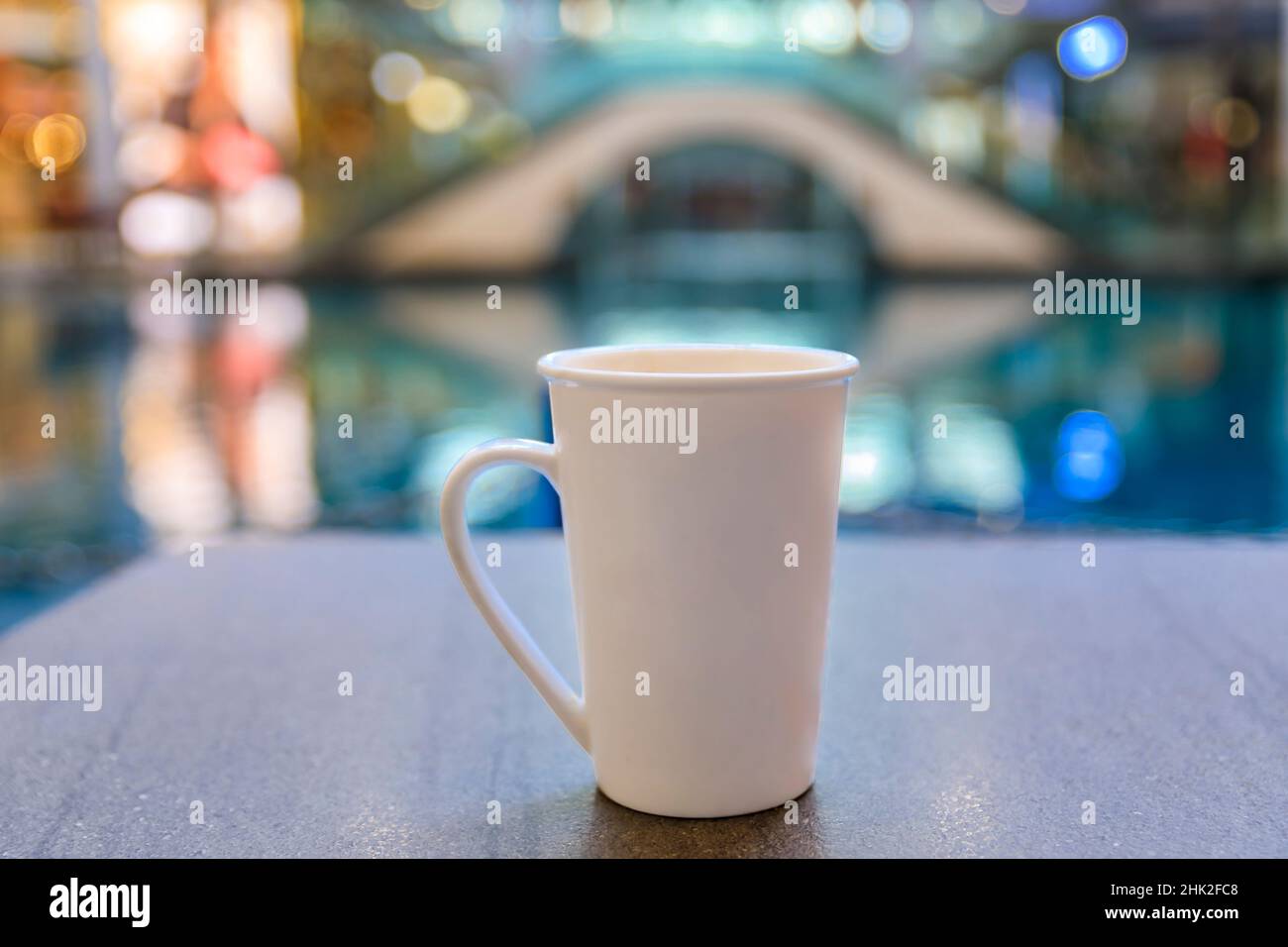Tazza di caffè su un tavolo in un caffè al coperto all'interno di un lussuoso centro commerciale con ristoranti e negozi di lusso a Singapore Foto Stock