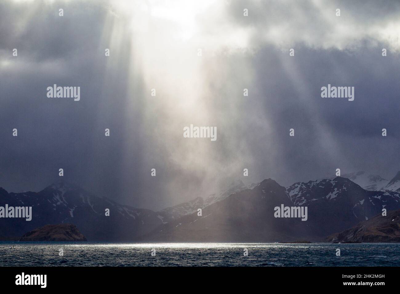 Oceano meridionale, Georgia meridionale, King Edward Cove, Grytviken. Il sole si rompe attraverso le nuvole a King Edward Point verso Grytviken. Foto Stock