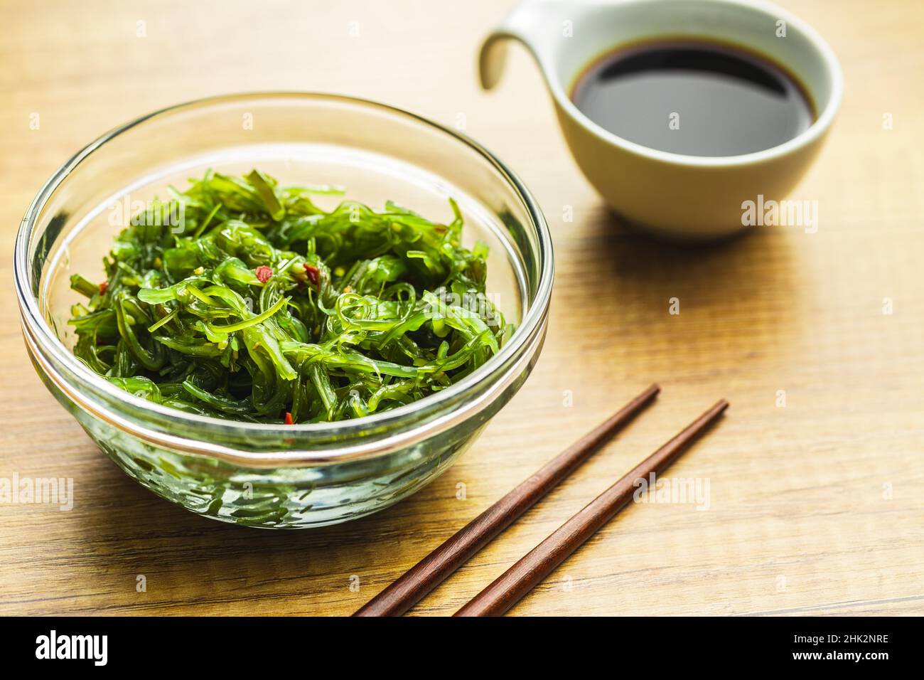 Wakame verde. Insalata di alghe e salsa di soia in una ciotola. Foto Stock