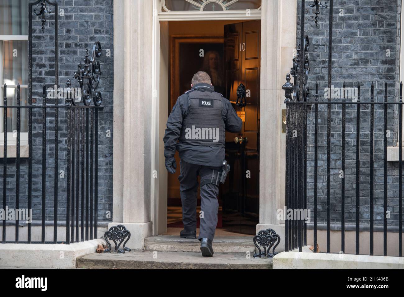 Downing Street, Londra, Regno Unito. 1 febbraio 2022. Un ufficiale di polizia Metropolitan entra nella porta d'ingresso a 10 Downing Street durante la riunione del gabinetto del mattino. Credit: Malcolm Park/Alamy Foto Stock