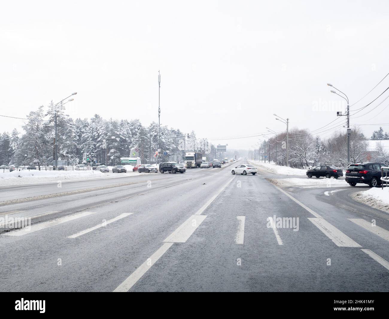 Regione di Mosca. Russia. Gennaio 29, 2022. Le auto attraversano un incrocio su un'autostrada suburbana. Il movimento di automobili su un'autostrada suburbana in un giorno d'inverno durante una nevicata. Foto Stock