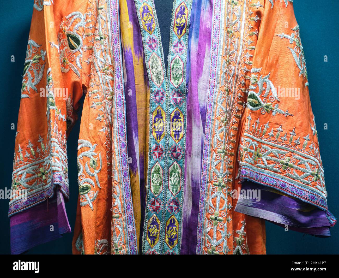 Un vecchio abito di seta arancione. Al Museo di Storia di Stato di Tashkent, Uzbekistan. Foto Stock