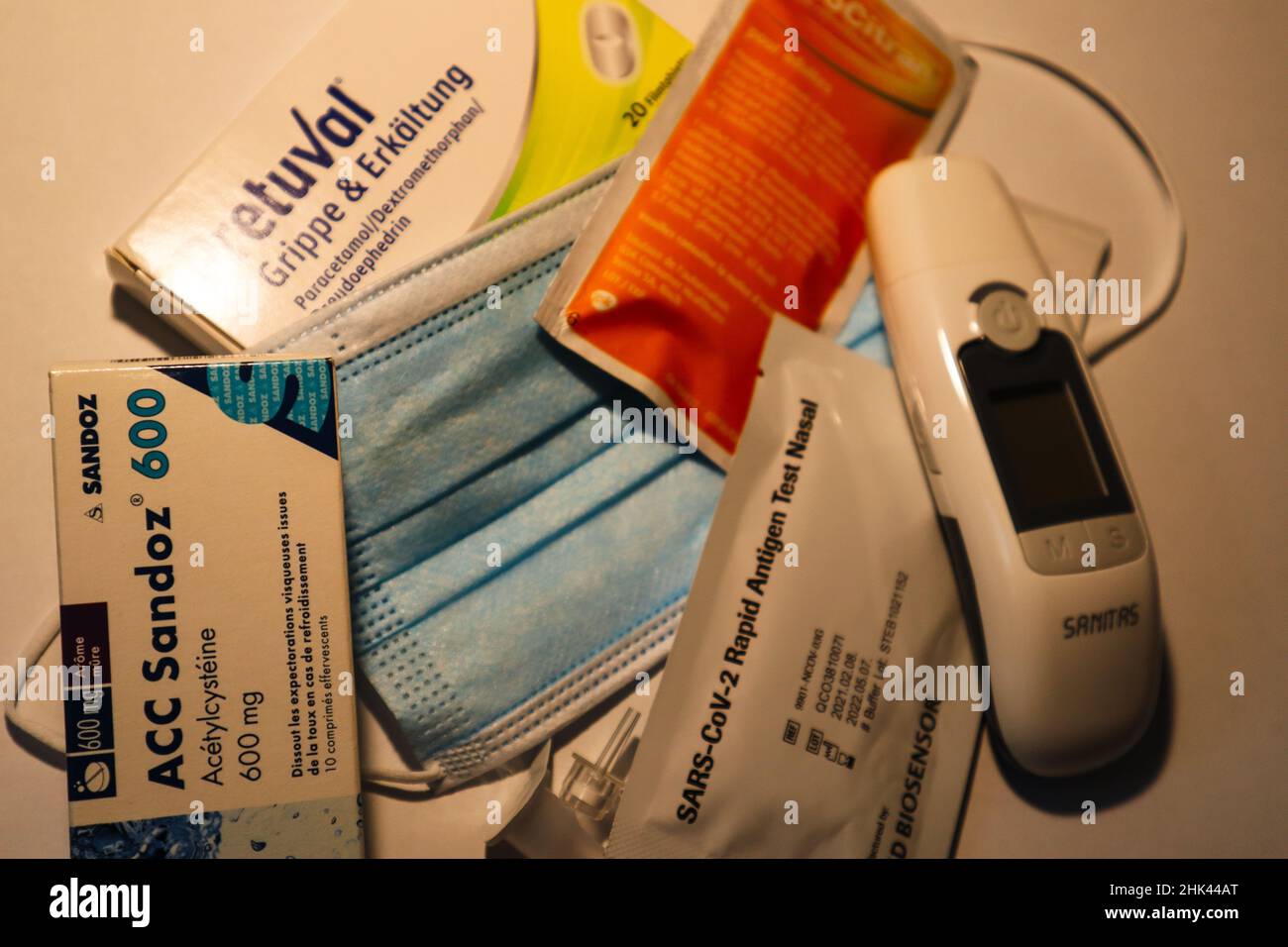 Berna, Svizzera, 05. Gennaio 2022: Maschera medica, termometro clinico e febbre, influenza e farmaci freddi. Foto Stock