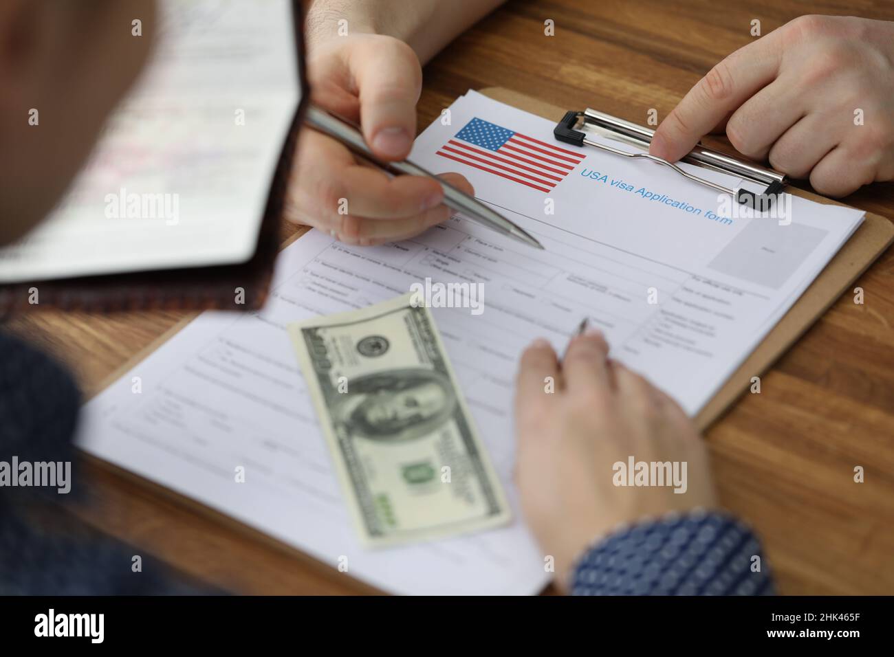 Uomo che compila i documenti per il visto americano con l'aiuto di consulente closeup Foto Stock