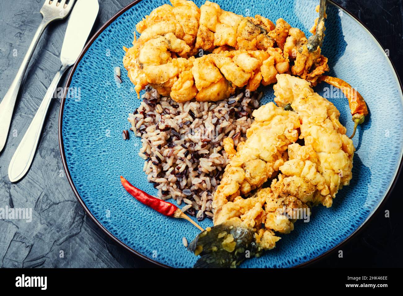 Pesce fritto di branzino con riso su carta di riso. Foto Stock