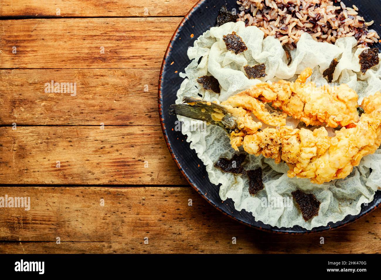 Pesce fritto di branzino con riso su carta di riso. Pesce arrosto. Spazio di copia Foto Stock