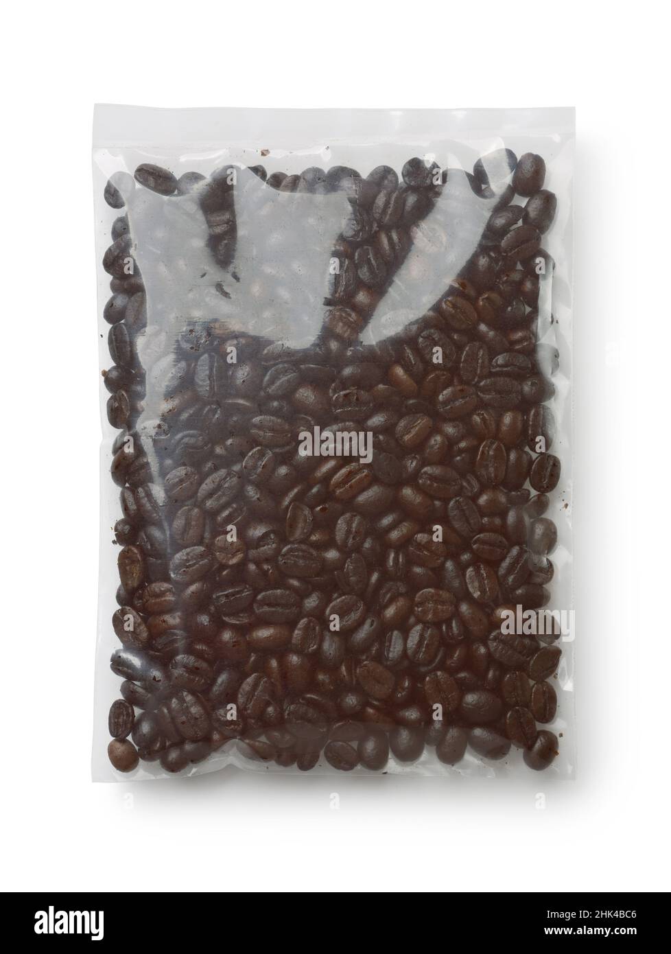 Vista dall'alto dei chicchi di caffè arabica tostati in sacchetto di plastica isolato su bianco Foto Stock