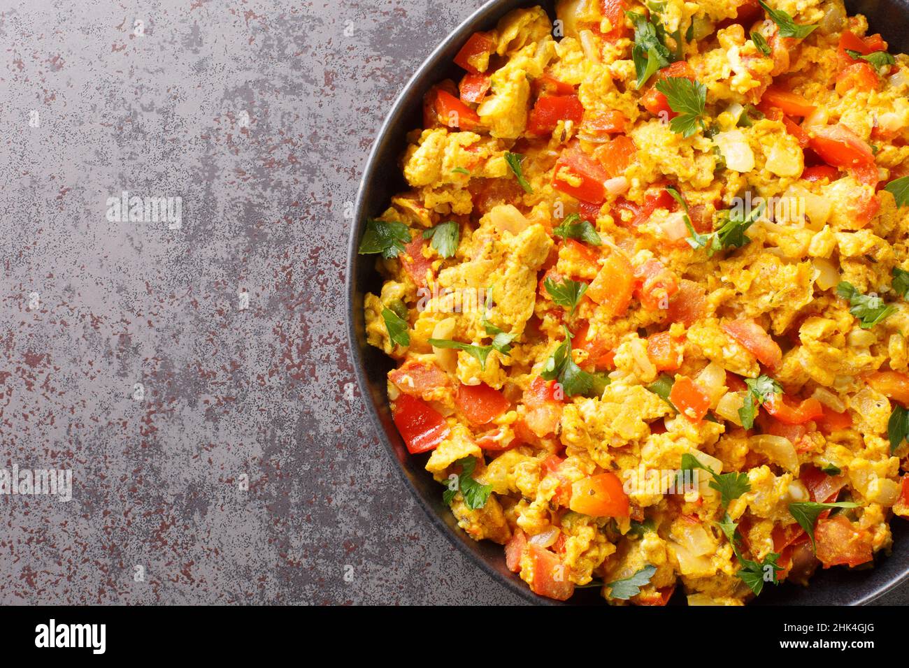 Perfetto uovo Bhurji speziato indiano uova strapazzate primo piano nel piatto sul tavolo. Vista dall'alto orizzontale Foto Stock